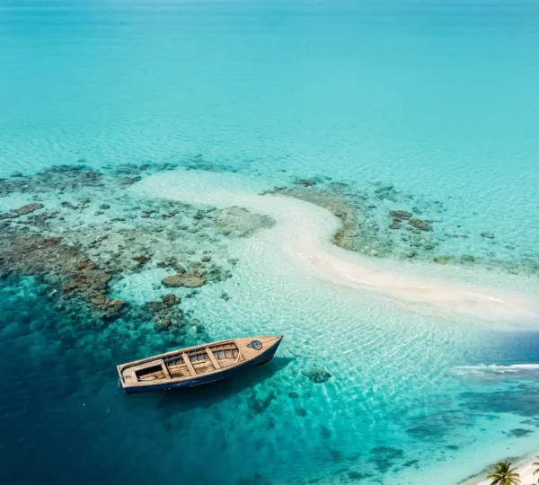 Vue aérienne d'une eau turquoise cristalline des Caraïbes révélant les fonds marins et un récif corallien en profondeur