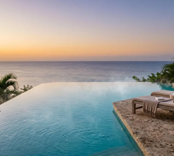Piscine à débordement luxueuse dont l'eau semble se fondre avec l'horizon de la mer des Caraïbes